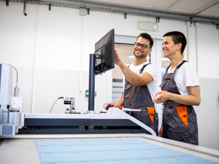 Zwei junge Menschen arbeiten gemeinsam an einer Maschine